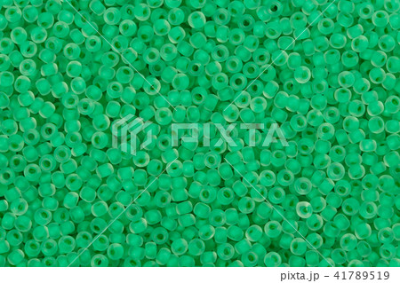 Green glass seed beads background. Green glass seed beads background. 41789519