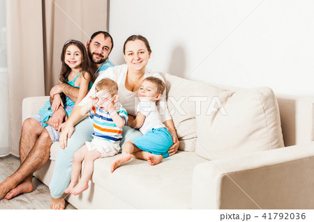 Happy parents with kids are sitting on the sofa. 41792036
