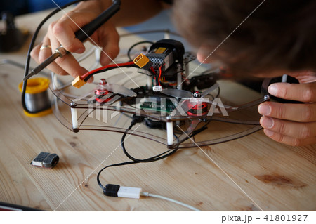 Image of young man with soldering iron chipping mechanism 41801927