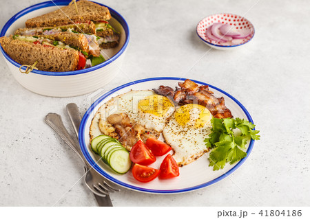 Fried eggs with bacon and a sandwich with meat Fried eggs with bacon and a sandwich with meat 41804186