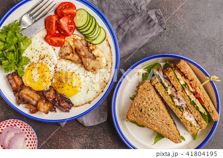 Fried eggs with bacon and a sandwich with meat Fried eggs with bacon and a sandwich with meat 41804195