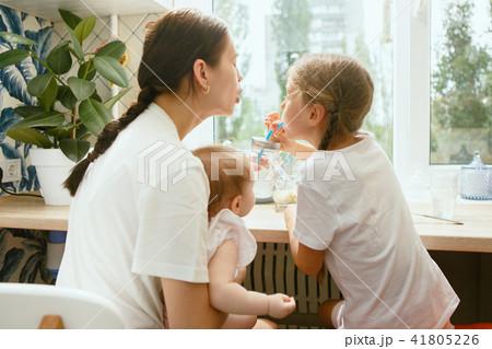 The happy smiling caucasian family in the kitchen preparing breakfast The happy smiling caucasian family in the kitchen preparing breakfast 41805226