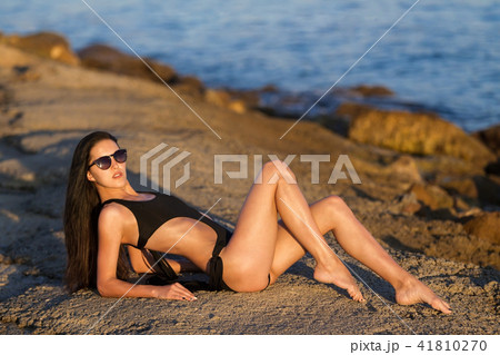beauty woman with perfect tanned body near an ocean 41810270