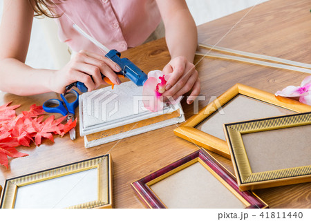 Woman decorating picture frame in scrapbooking concept 41811440