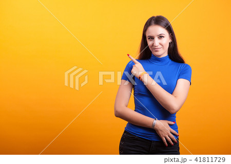 Smilling pretty woman pointing away Smilling pretty woman pointing away 41811729