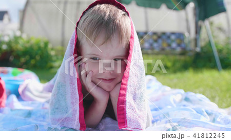 A little boy lying on the lawn on a hot summer day. The child is fun and active to spend their A little boy lying on the lawn on a hot summer day. The child is fun and active to spend their 41812245