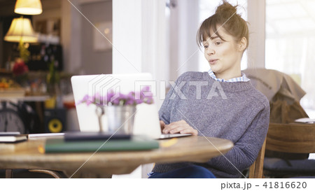 A young surprised cute brunette girl is working with a laptop in a cafe 41816620