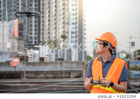 Asian engineer flying drone over construction site 41823284
