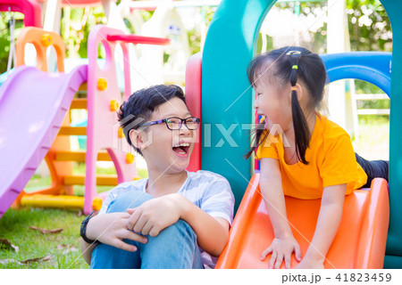 Young boy playing with his sister at playground 41823459