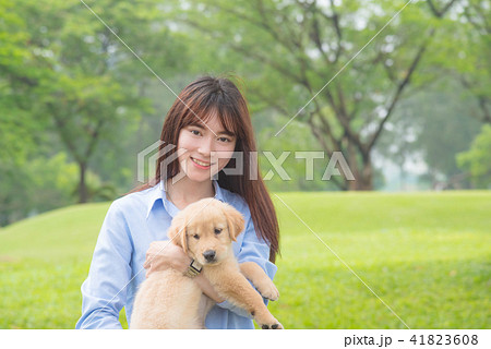 Beautiful girl smiling with her little dog in park 41823608