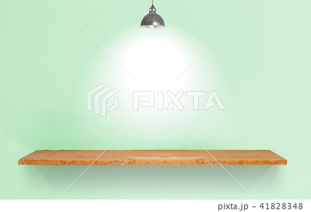 Wooden shelf with lamp on green vintage wall. 41828348