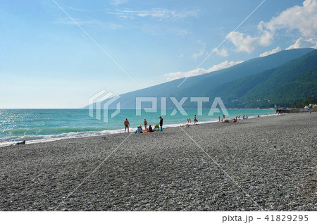 People relax on the azure Black sea pebble beach 41829295