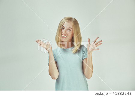 The happy freckled woman standing and smiling against gray background. The happy freckled woman standing and smiling against gray background. 41832243