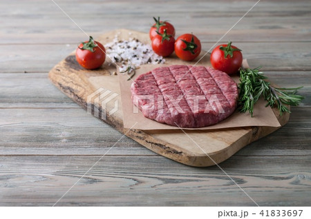 Raw hamburger cutlet on a wooden board 41833697