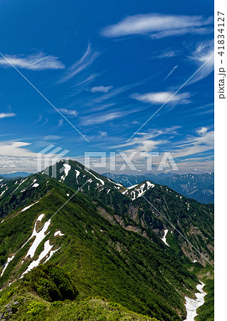越後駒ヶ岳稜線から見る中ノ岳と青空 41834127