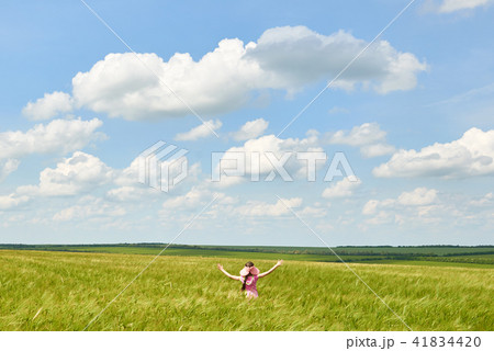 child is in the wheat field, bright sun, summer   41834420