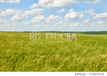 child is in the wheat field, bright sun, summer   41834422