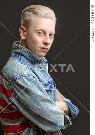 Handsome blonde american man in denim jaket isolated over black background 41836749