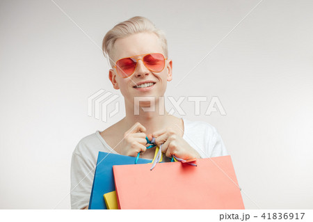 Portrait of fashion young man in pink glasses with shopping bags Portrait of fashion young man in pink glasses with shopping bags 41836917