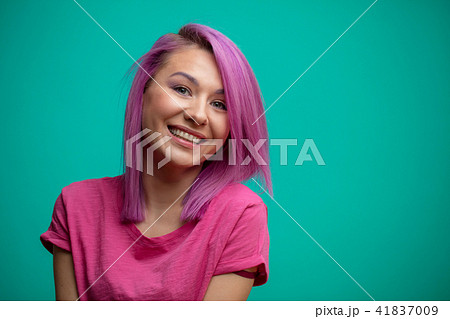 Young female model with pink hair, smiling broadly, feeling joy. 41837009