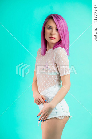 Fit woman with violet hair, dressed in transparent blouse and shorts isolated Fit woman with violet hair, dressed in transparent blouse and shorts isolated 41837547