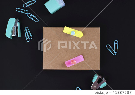 Many multi-colored paper clips and paper on a black background. Office concept. Subjects for the 41837587