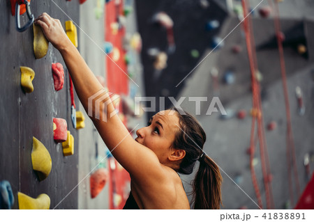Sporty young woman training in a colorful climbing gym. Sporty young woman training in a colorful climbing gym. 41838891