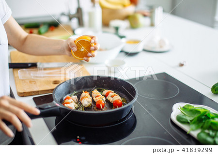Cropped view of young happy housewife frying chicken meat for dinner 41839299