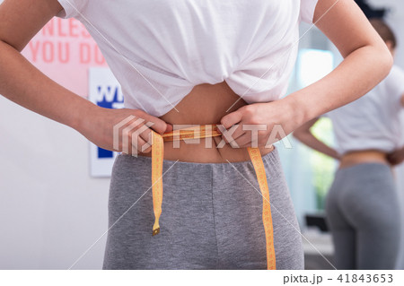 Smooth female hands falsifying waist measurement 41843653