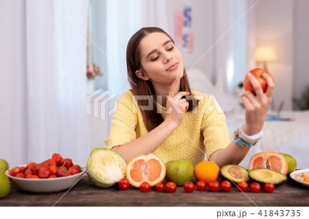 Pensive teen girl selecting fruit Pensive teen girl selecting fruit 41843735