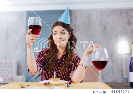 Woman making funny face while attending birthday party 41844175