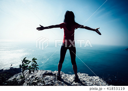 freedom female standing on sunrise windy coast 41853119