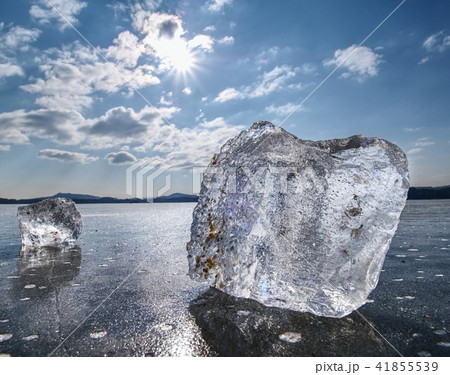 Ice shards on a frozen lake. The rays of the sun  41855539