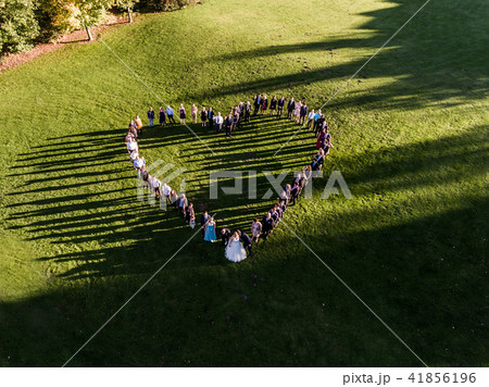 Wedding guests lined up in the shape of heart with bride and groom marriage people 41856196
