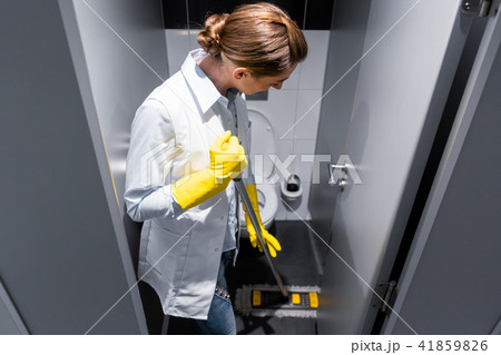 Cleaning lady or janitor mopping the floor in restroom Cleaning lady or janitor mopping the floor in restroom 41859826