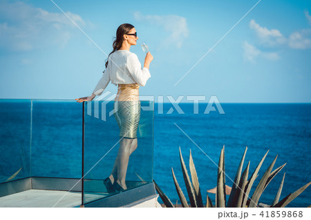 Woman enjoying glass of champagne at the sea 41859868
