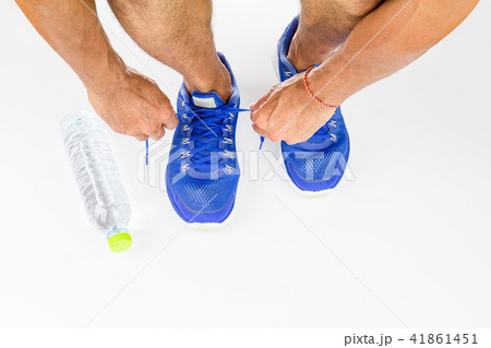 Man lacing sport shoes with drinking water bottle  41861451