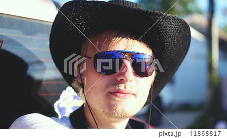 Handsome cowboy in hat and sunglasses traveling in a pickup truck in sunny day Handsome cowboy in hat and sunglasses traveling in a pickup truck in sunny day 41868817