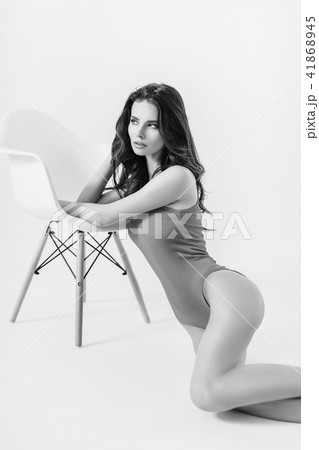 Woman in swimsuit leaning on chair 41868945