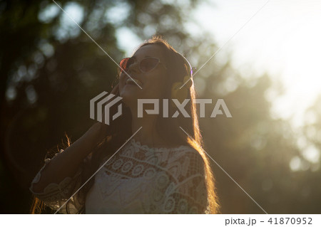 Portrait of woman with headphones out in nature. 41870952