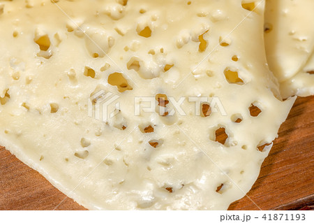 close up of holes cheese sliced on wooden texture close up of holes cheese sliced on wooden texture 41871193