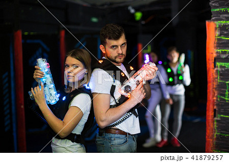 Two laser tag players standing back to back Two laser tag players standing back to back 41879257