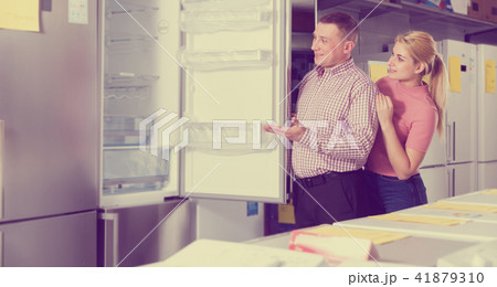 Family couple looking new refrigerator in appliances store 41879310