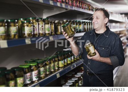 Man selecting cucumbers at store 41879323