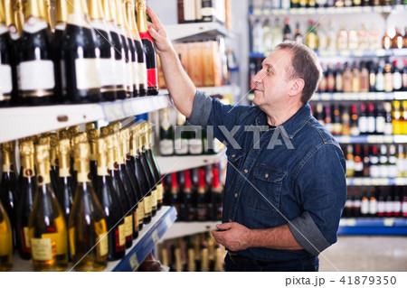 Man buying wine at store Man buying wine at store 41879350