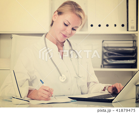 portrait of adult adult therapist writing and working with laptop in office workplace 41879475