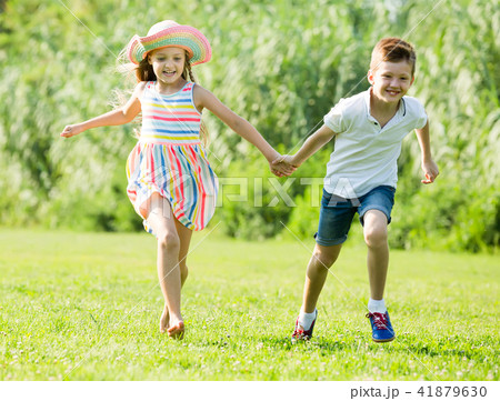 two smiling children active playing and running outdoors two smiling children active playing and running outdoors 41879630