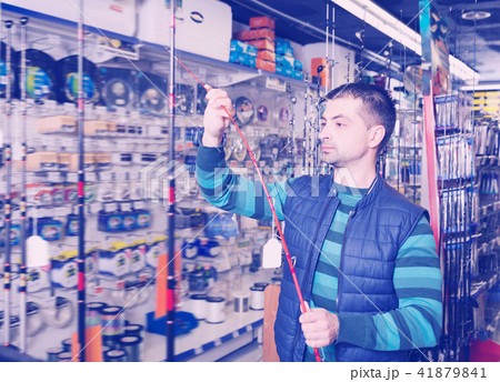 Attentive fisherman looking new fishing rod 41879841