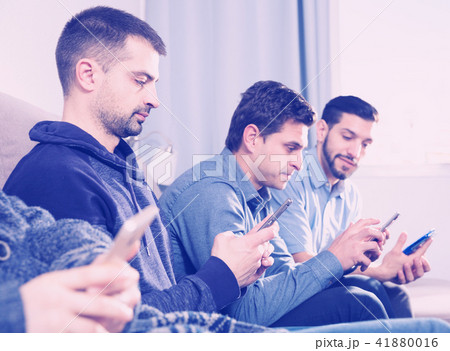 Three men with smartphones at home 41880016