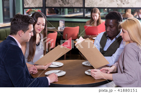 Happy people discussing restaurant menu Happy people discussing restaurant menu 41880151